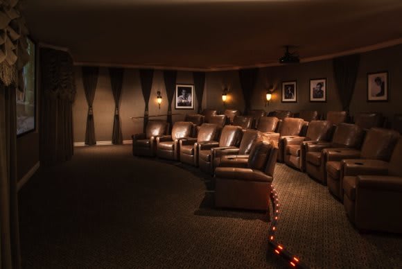 A cozy home theater with comfortable recliners and dim lighting for an immersive cinema experience.