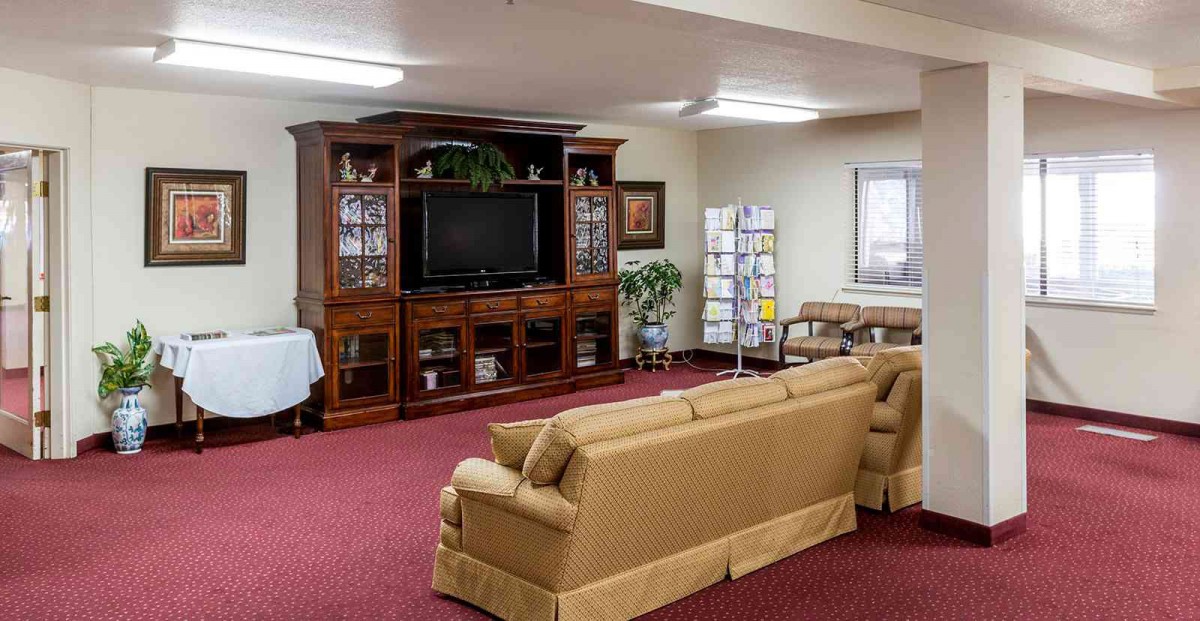 A cozy living room with a large entertainment center and comfortable seating.