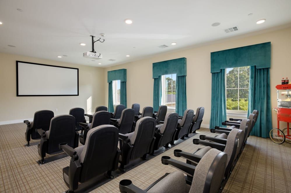 A well-organized conference room with theater-style seating and a projector screen.