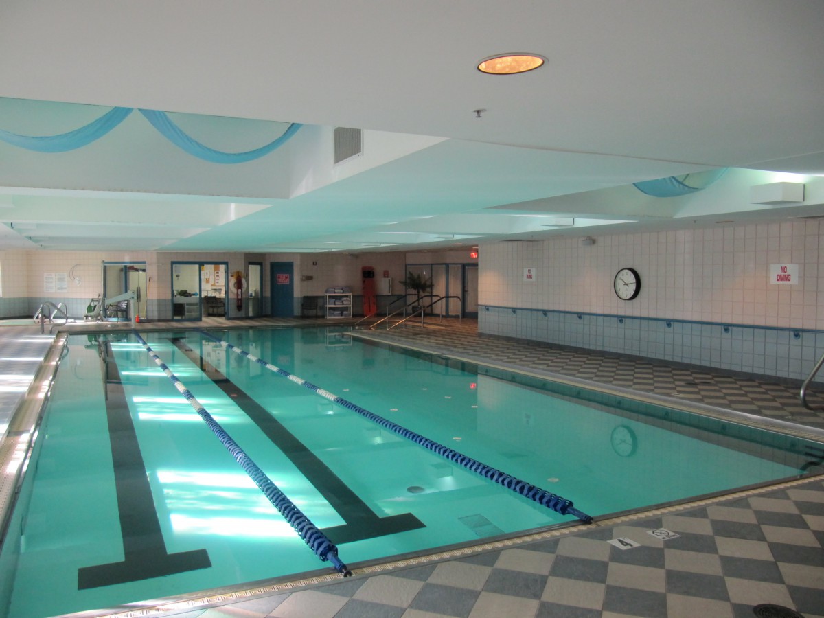 An indoor swimming pool with marked lanes and natural lighting.