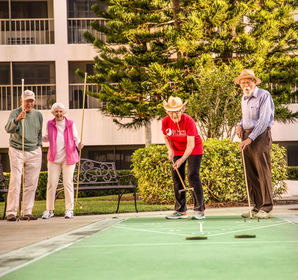 A group of seniors enjoying a game of shuffleboard outdoors.