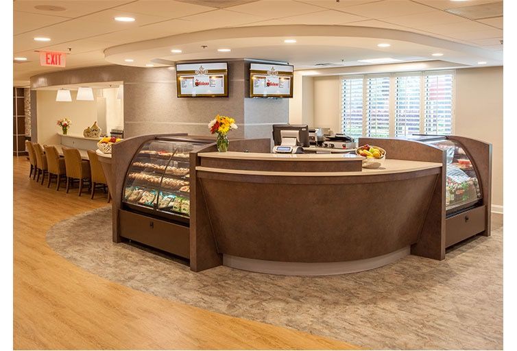 A modern cafe interior with a curved counter and a display case.