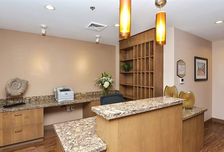 A modern office reception area with a granite countertop and stylish lighting.