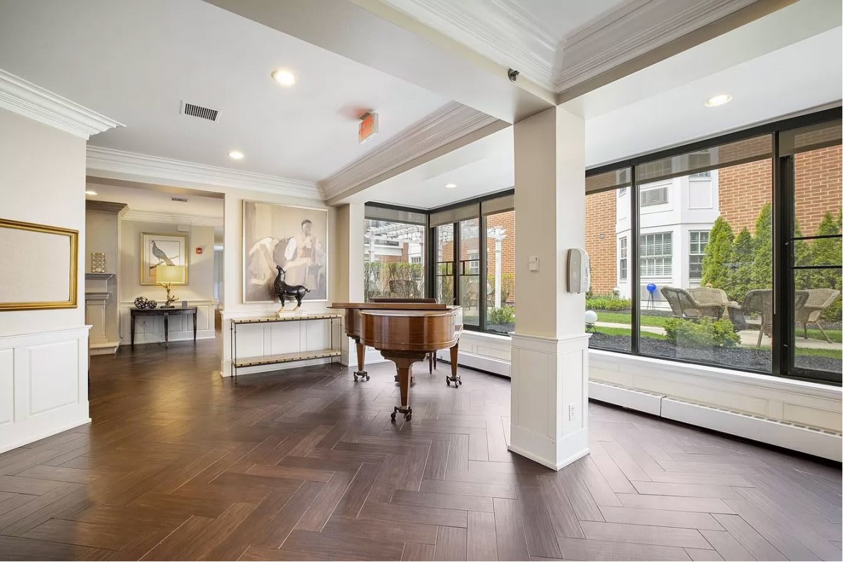 A modern interior space featuring a grand piano and large windows.