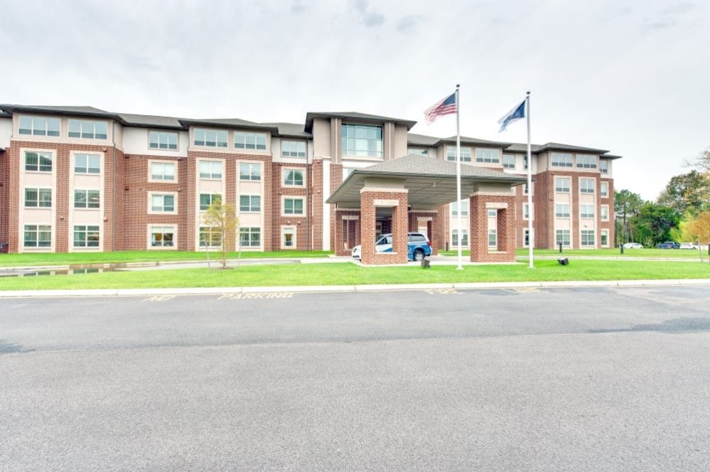 Exterior view of a hotel with flags flying near the entrance.