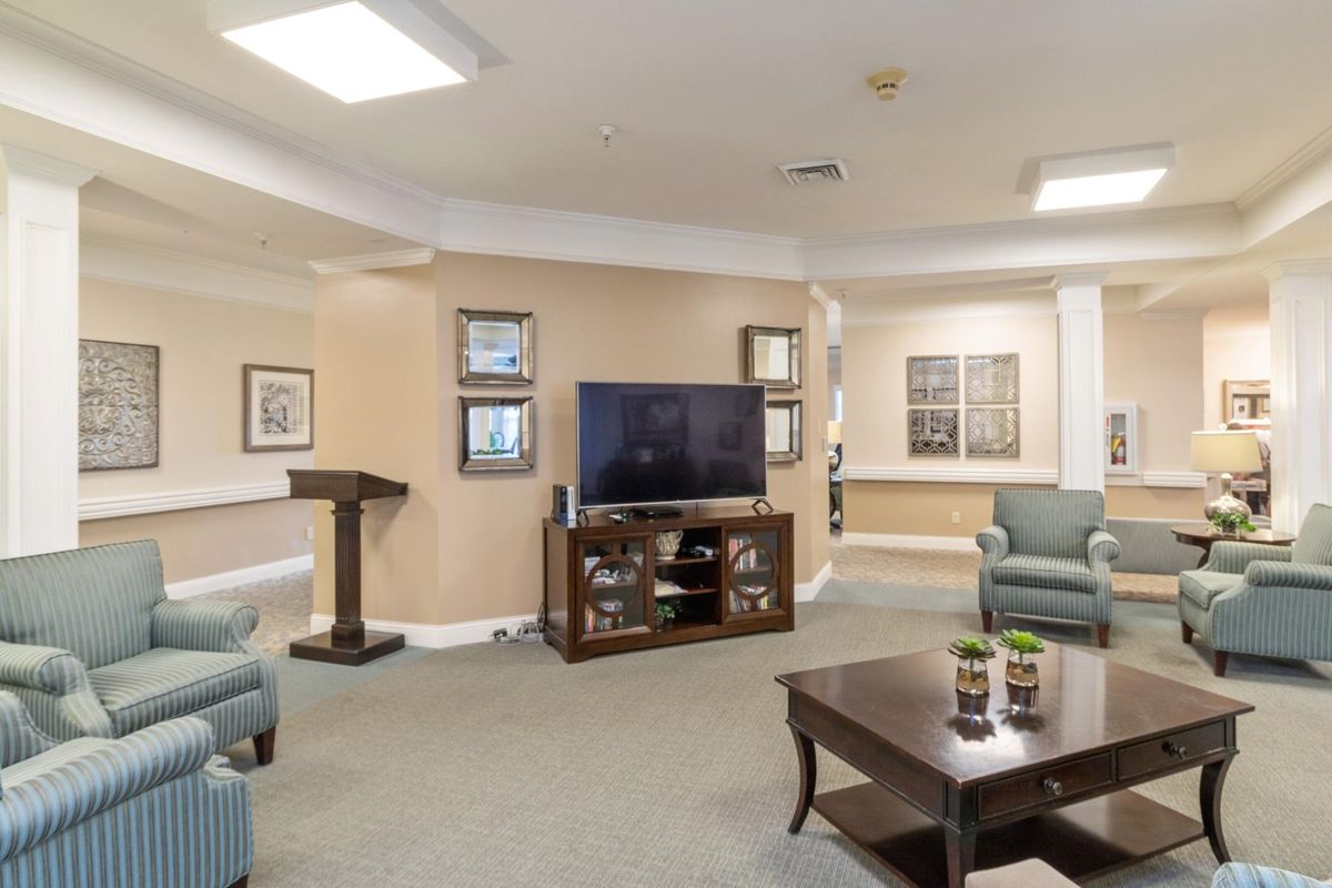 A modern living room with a TV, comfortable chairs, and a coffee table.