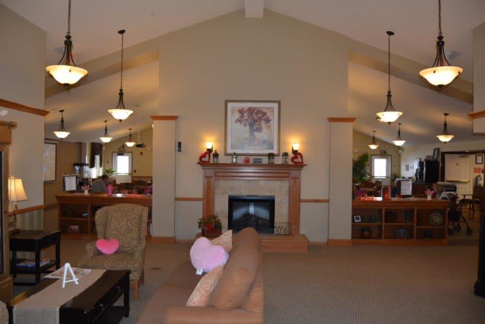 A cozy living room with a fireplace, artwork above the mantle, and comfortable seating.