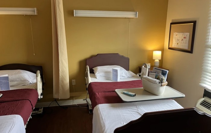 A well-lit hospital room featuring a medical bed with surrounding equipment.