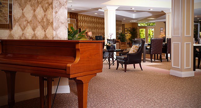 A cozy lounge area featuring a piano and comfortable seating.