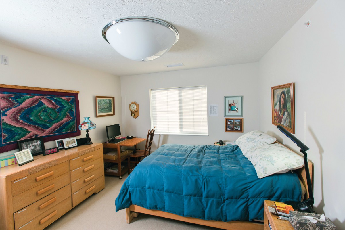 A cozy bedroom with blue bedding and wooden furniture.