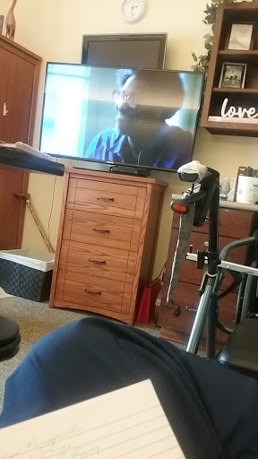 A cozy living room setup featuring a television and a wheelchair.
