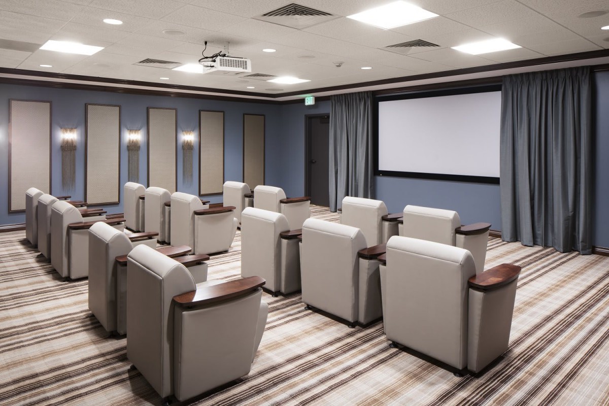 A stylish home theater with comfortable seating and a large projector screen.