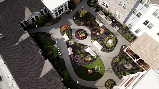 A beautifully landscaped garden featuring winding pathways, seating areas, and vibrant plants.