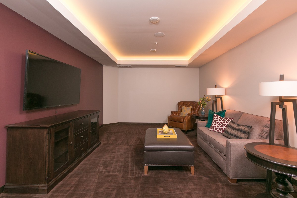 A cozy, modern living room with a sofa, TV, and stylish lighting.
