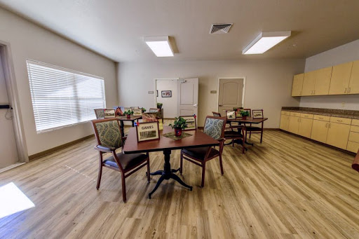 A spacious and well-lit dining area featuring multiple tables and chairs, designed for communal gatherings.