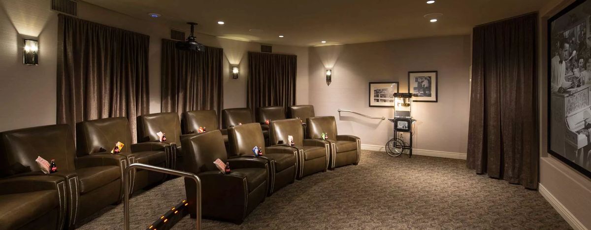 A cozy home theater with leather seating and a projector setup.