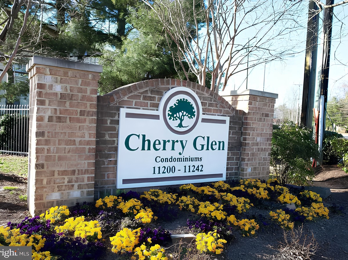 Entrance sign for Cherry Glen Condominiums surrounded by vibrant flowers.