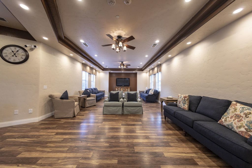 A spacious and modern living room with elegant furnishings and wooden flooring.