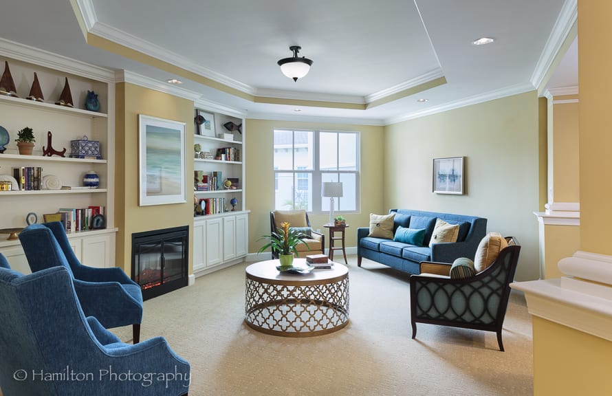 A cozy living room with comfortable seating, a stylish coffee table, and built-in shelves displaying decor.
