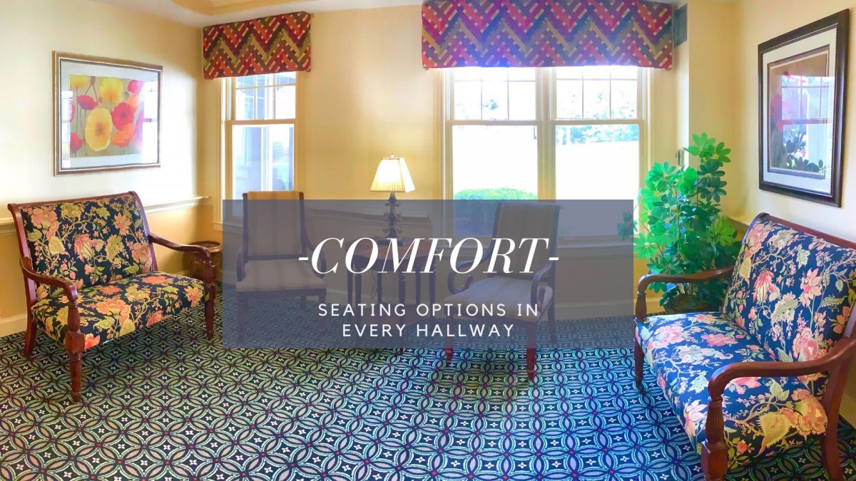 A cozy seating area in a hallway with comfortable furniture and warm lighting.