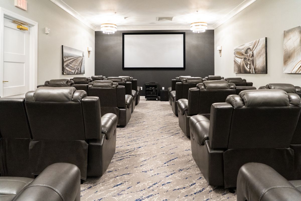 A luxury home theater with comfortable seating and a large screen.