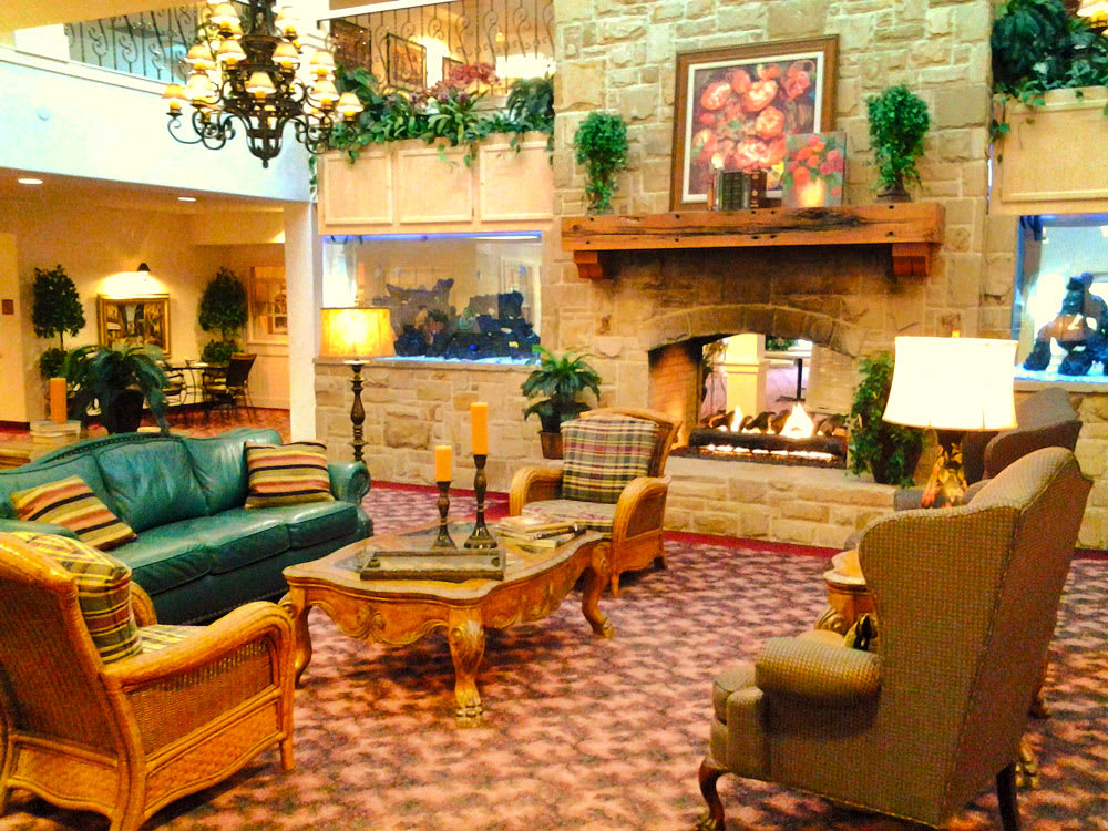A cozy hotel lobby with comfortable seating and a warm fireplace.