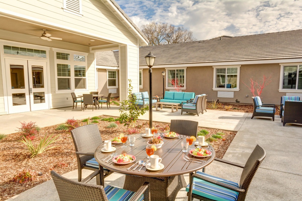 A cozy outdoor patio setup with a round table and chairs, perfect for enjoying meals on a sunny day.