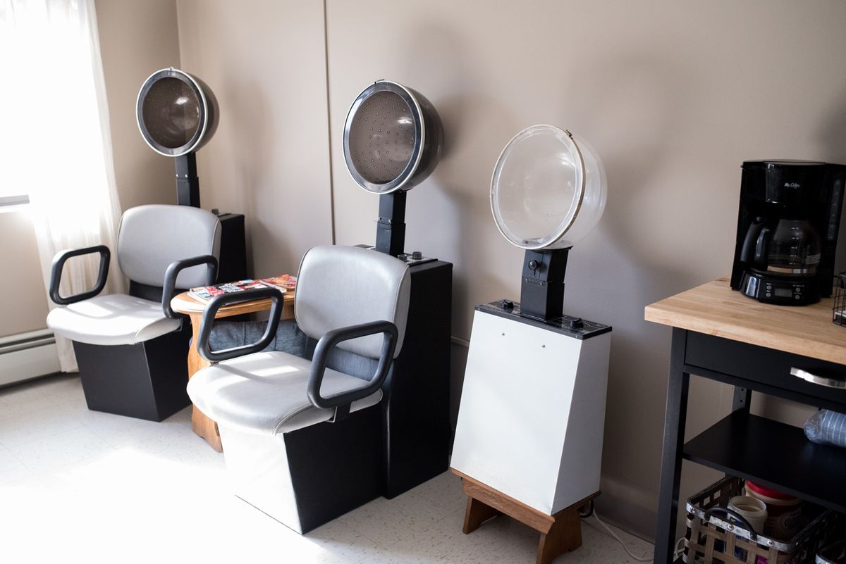 A hair salon setup with chairs and hair dryers.