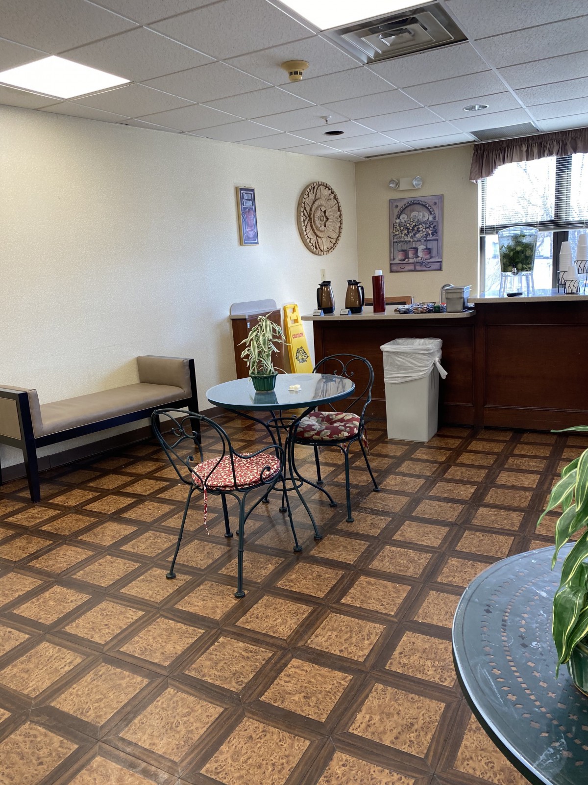 A small waiting area with a table, chairs, and a coffee station.