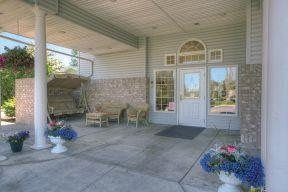 A welcoming entrance with outdoor seating and decorative plants.
