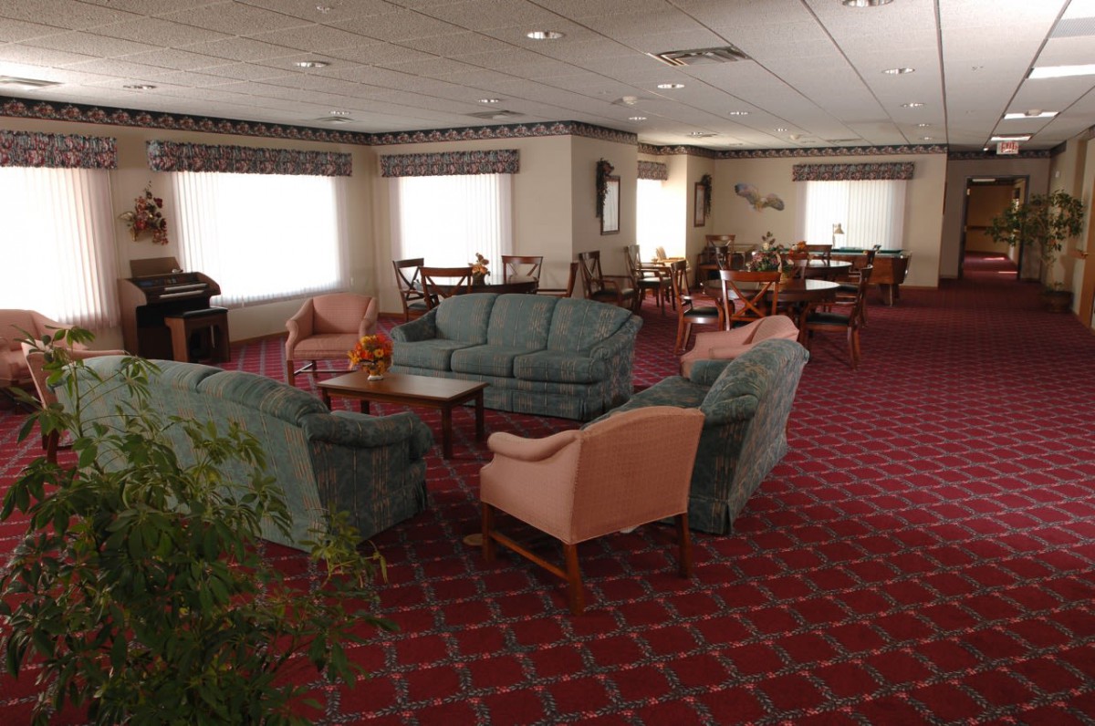 A spacious lounge area with comfortable seating and a warm carpeted floor.