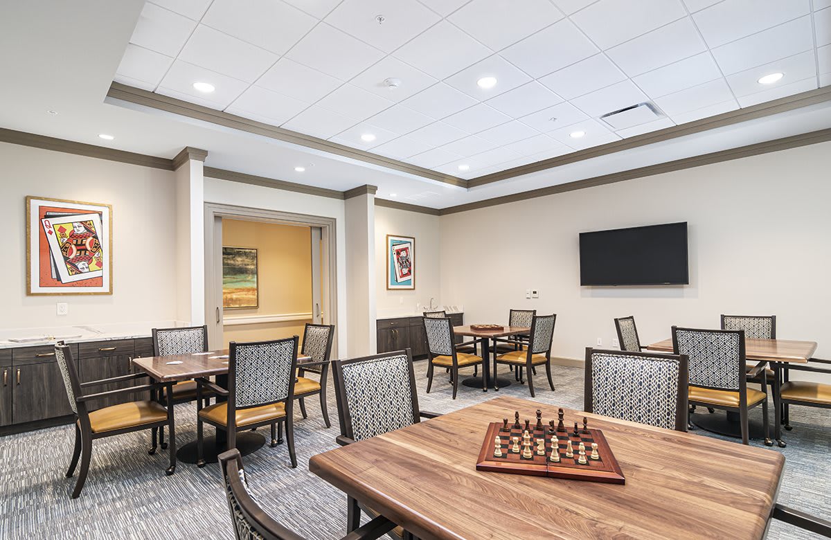 A modern meeting room featuring a chess set on the table, with multiple tables and chairs arranged for collaborative use.