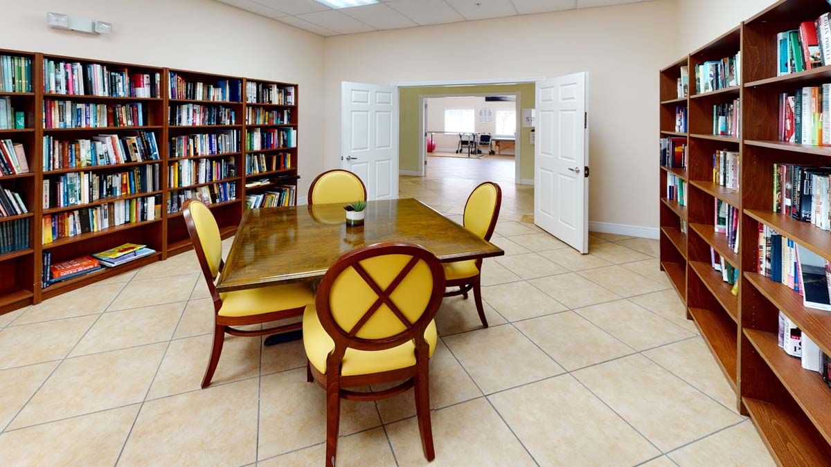A library conference room with a table and chairs, surrounded by bookshelves.