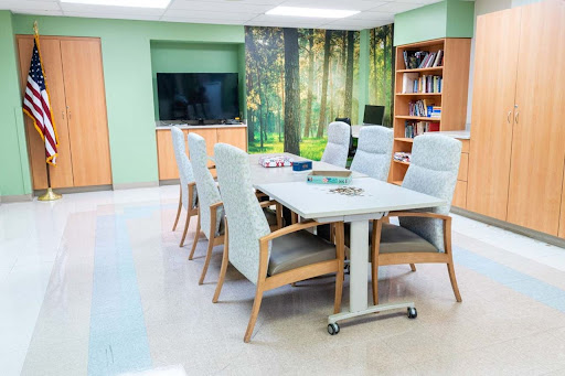 A modern conference room featuring a large table, comfortable chairs, and nature-themed decor.