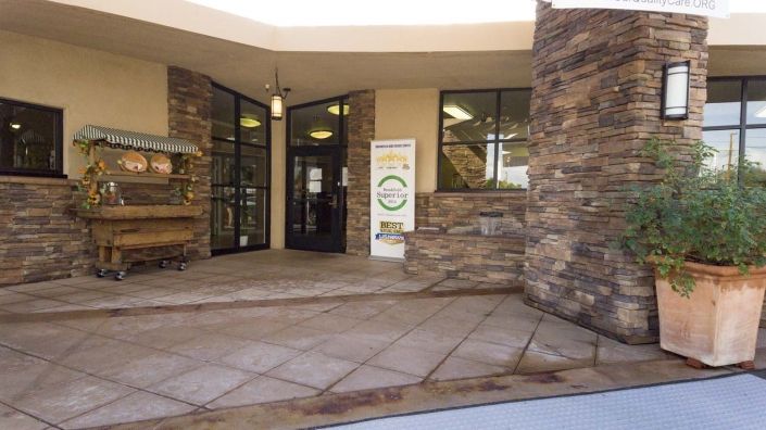 The entrance to a building featuring a stone facade and glass doors.