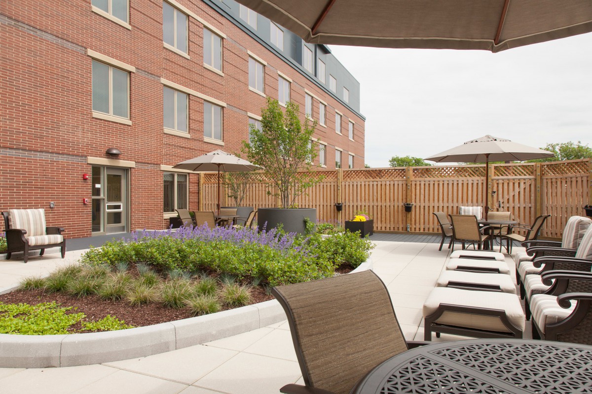 Outdoor patio area of a hotel with seating and landscaping.