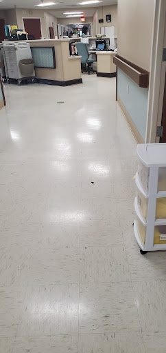 A clean hospital hallway with a storage unit on the side.