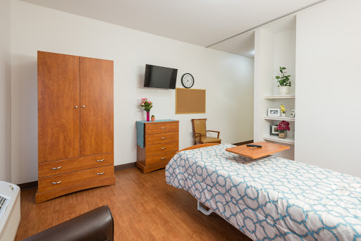 A well-designed hospital room featuring wooden furniture and a cozy atmosphere.