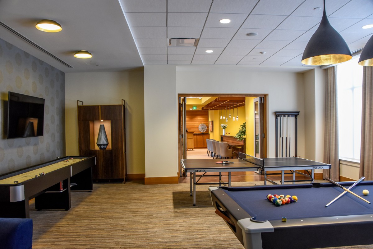 A modern game room featuring a pool table and a ping pong table, designed for recreational activities.