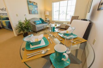 A beautifully arranged dining table with turquoise accents in a cozy living room setting.