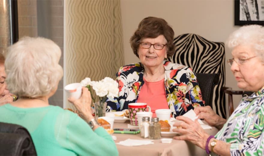 Elderly people enjoying a meal together indoors.