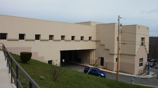 A view of a modern, beige concrete building with multiple windows.