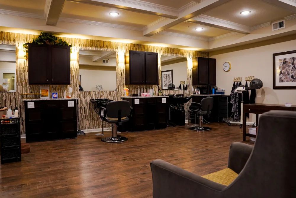 A stylish and modern salon interior with chairs, mirrors, and warm lighting.