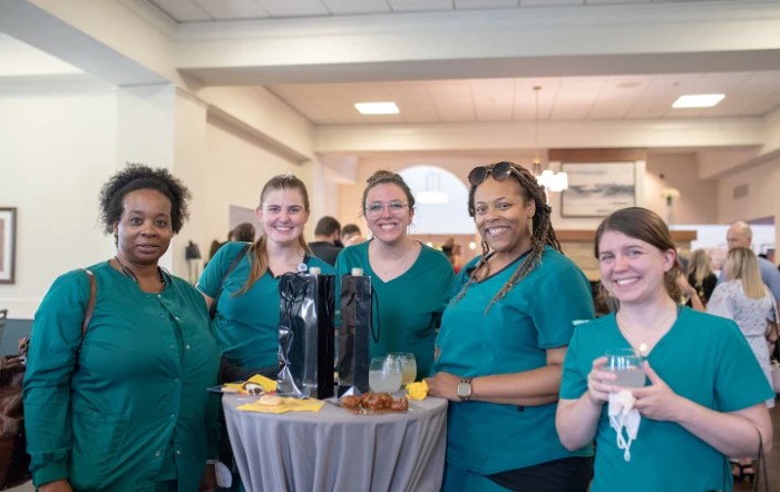 A group of healthcare professionals smiling and enjoying a gathering.