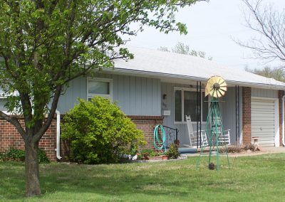 A suburban house with a well-maintained front yard and tree.