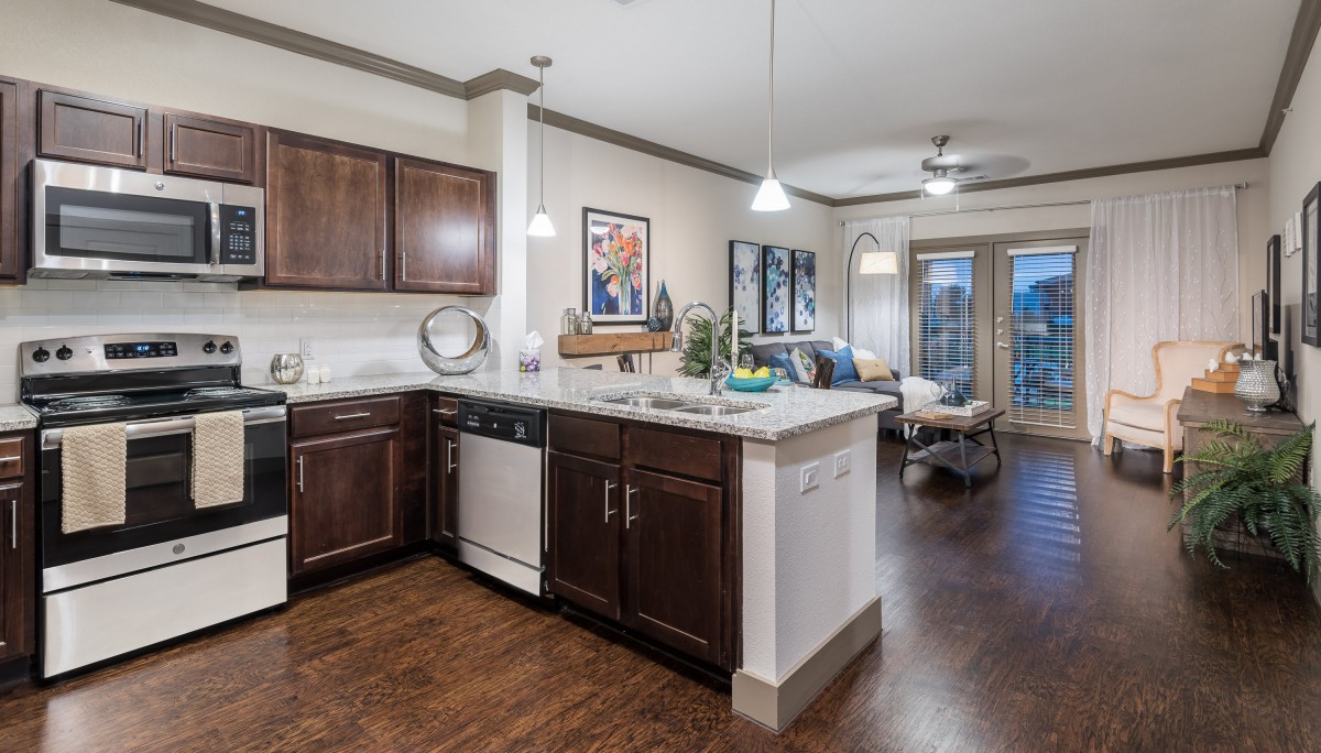 A modern open-plan kitchen and dining area with wooden flooring and stylish lighting.