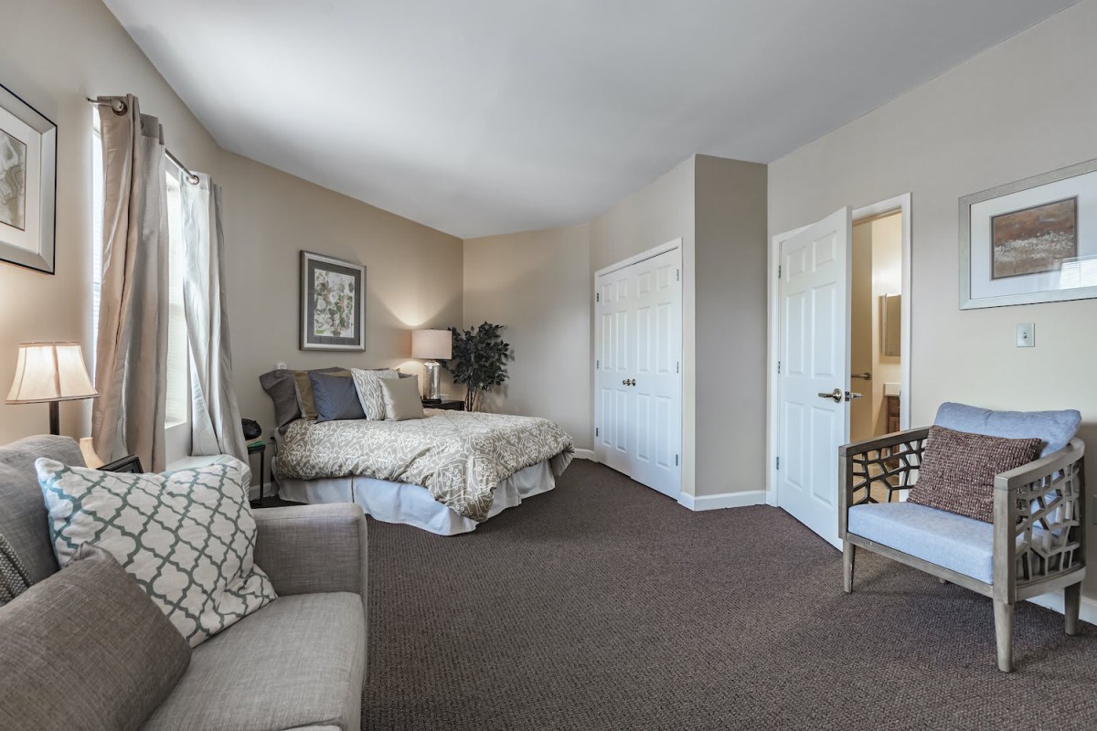 A spacious and modern bedroom with elegant furnishings and ample natural light.