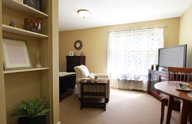 A cozy living room with a comfortable chair and large window.