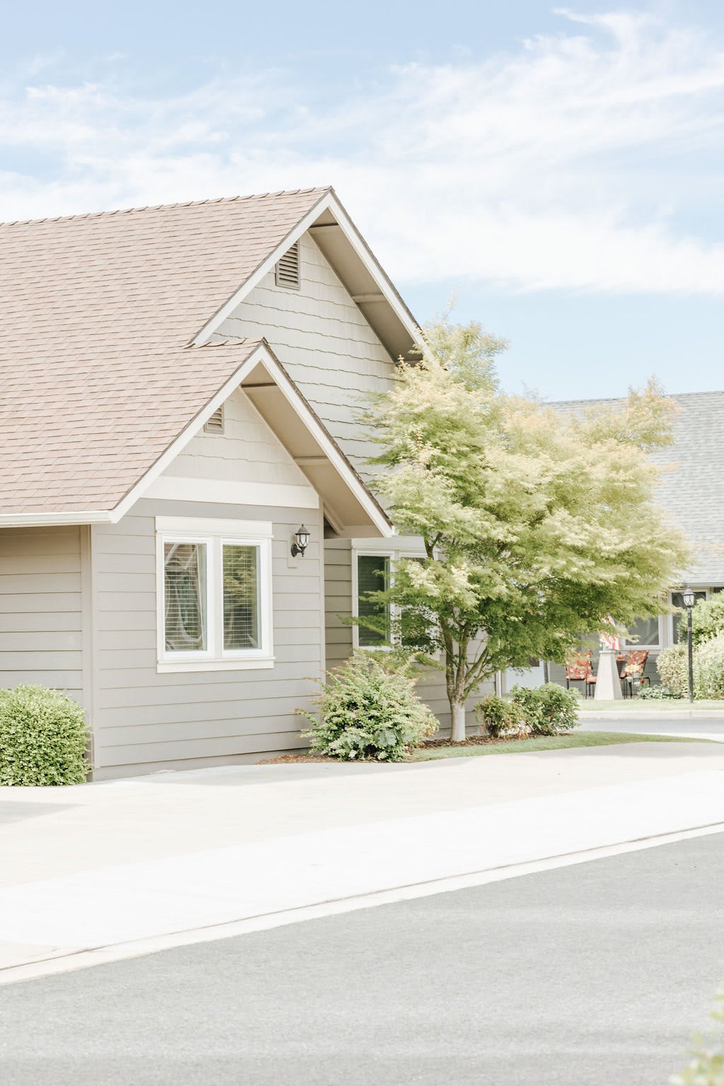 A suburban house with a well-maintained yard and a tree.