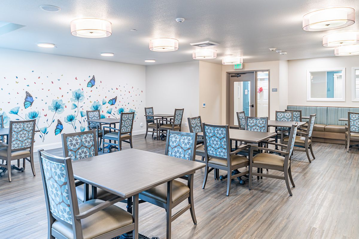 A modern dining area featuring patterned chairs and wooden tables, with stylish decor on the walls.